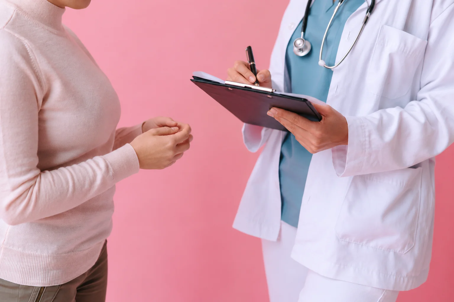 Healthcare professional making notes on a clipboard during a consultation